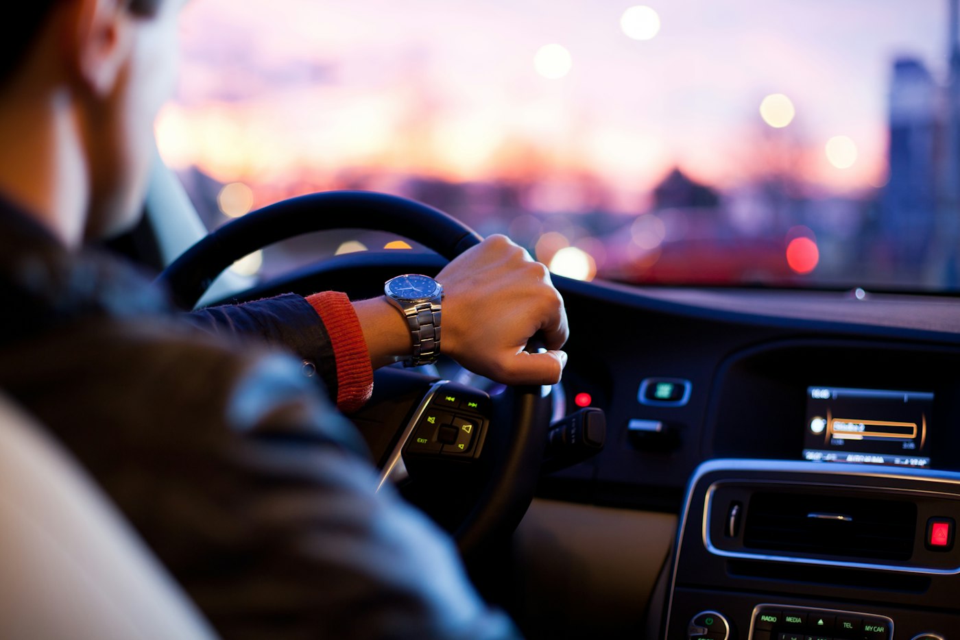 A driver on an open road at dusk