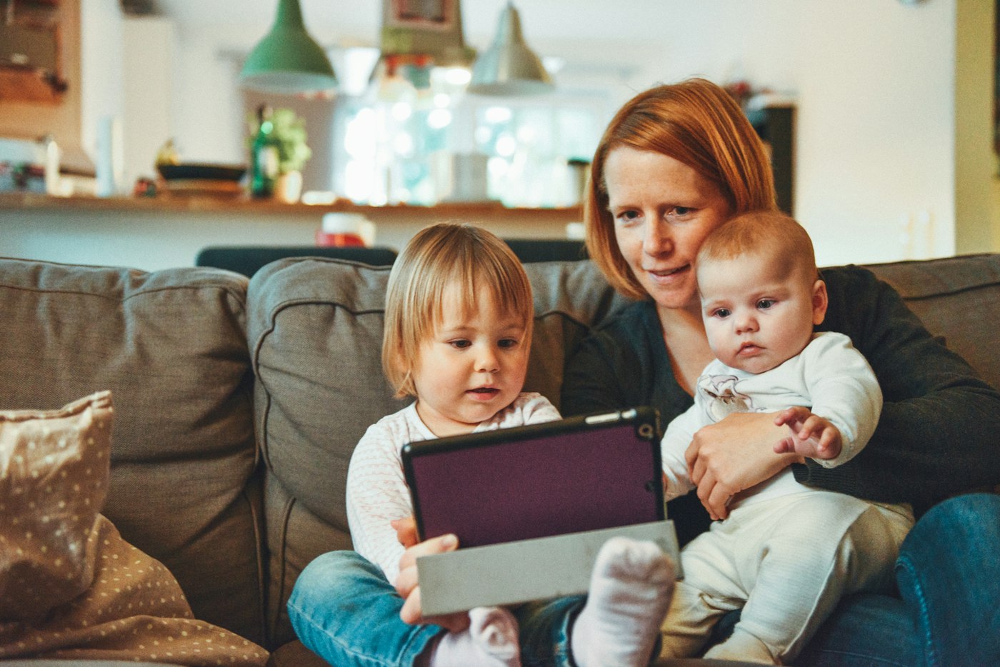 A parent sitting with two young children